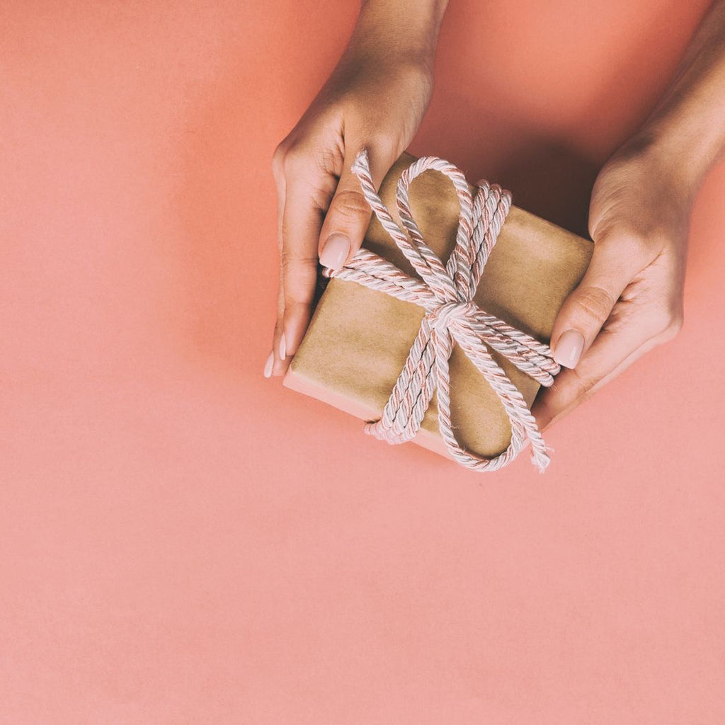 Womans hands holding a sustainably wrapped gift