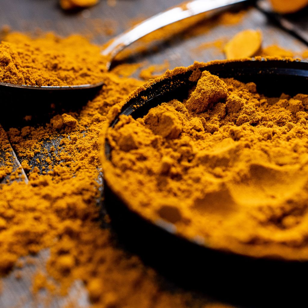 Ground turmeric in a spoon and bowl